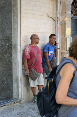 ITALY, FAVIGNANA-20 OCTOBER:  Favignana is very popular islang for rest. Two workers men after work waiting on a street on 20 October  2022, Favignana, Sicily.のeditorial素材