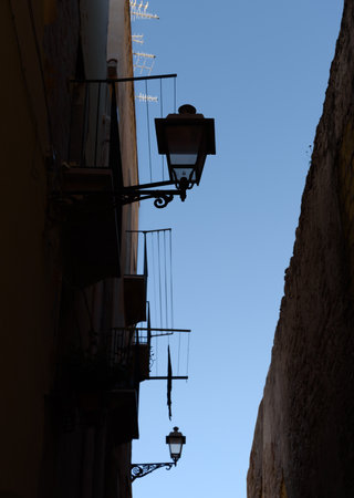 Old buildings with lamps on a narrow street in Italy.の写真素材