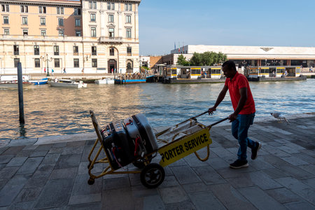 ITALY, VENICE - JUNE 16: Venice is a city in the northeast of Italy. View of the canal and working people on a sunny day June 16, 2022, Venice, Italy.のeditorial素材