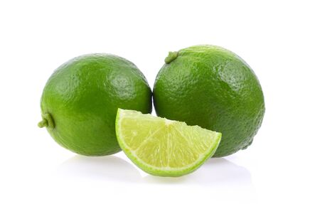 whole and slice fresh green lime isolated on white backgroundの写真素材