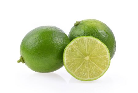 whole and slice fresh green lime isolated on white backgroundの写真素材
