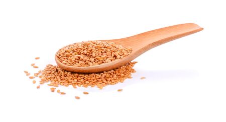 Golden flax seed in a wooden spoon on white background.の写真素材