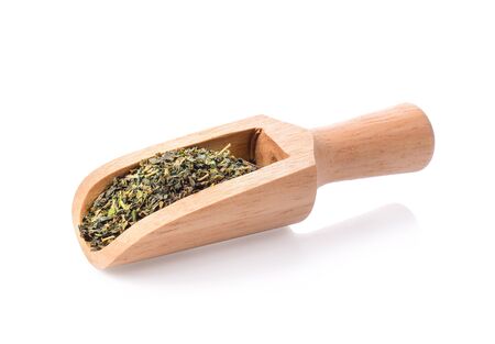 Dry green tea in wooden scoop on white background.の写真素材