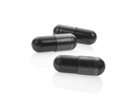Charcoal capsules on white background.の写真素材