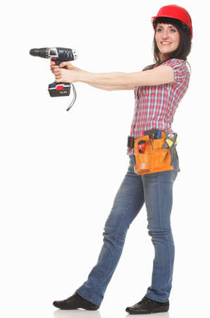 Woman standing on a white background with electric screwdriver in handsの写真素材