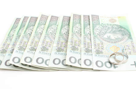 Two wedding rings and money on a white background
