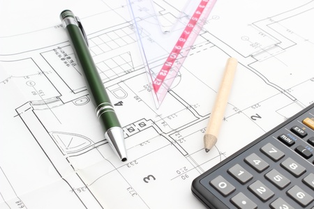 Drawing accessories and calculator on construction drawing of house