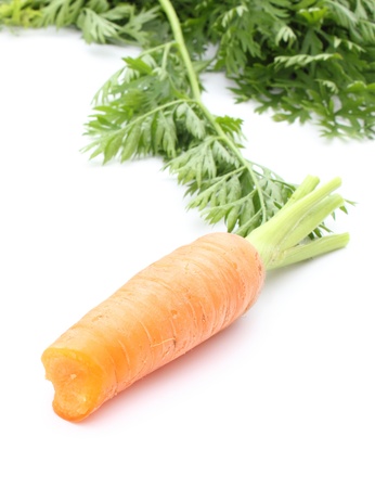Closeup of orange carrot with leaves isolated on white backgroundの写真素材