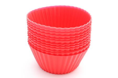 Stack of red silicone cups for cupcakes isolated on white の写真素材