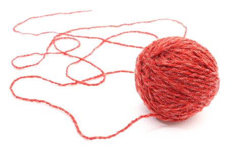 Closeup of entangled red wool and wool ball on white backgroundの写真素材