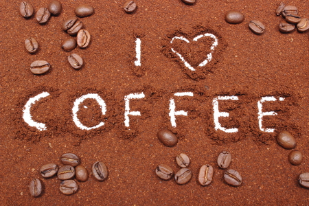 Coffee word written on ground coffee and coffee grainsの写真素材