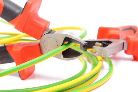 Metal pliers with tangled green-yellow electric cable, pliers cut the cable  Isolated on white...