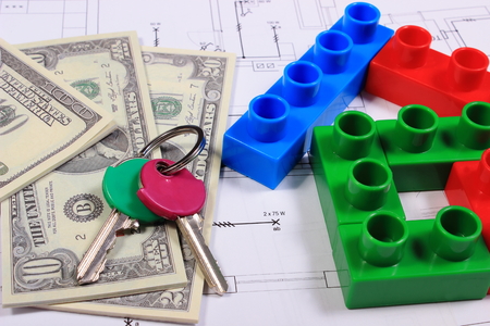 House shape of colorful building blocks, home keys and banknotes on construction drawing of house, concept of building houseの写真素材