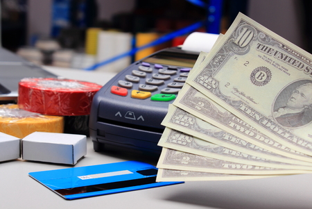 Money and payment terminal with credit card in an electrical shop, paying for shopping, finance conceptの写真素材