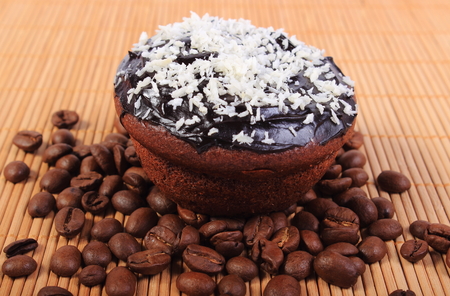 Homemade delicious fresh baked chocolate muffins with desiccated coconut and coffee grains on wooden background, concept for dessertの写真素材