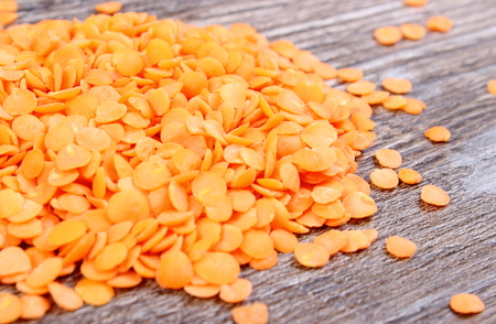 Heap of raw red lentil lying on wooden background, concept for healthy nutrition and eatingの写真素材