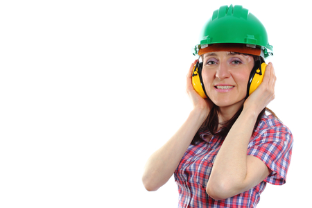 Smiling female construction worker wearing green helmet and protective headphones, safety at work and ear protection, copy space for text. White backgroundの写真素材