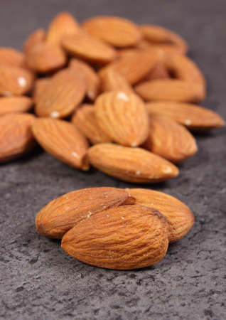 Heap of fresh healthy almonds on structure of concrete, concept for healthy nutritionの写真素材