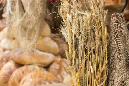 Ears of rye grain and heap of freshly baked traditional loavesの写真素材