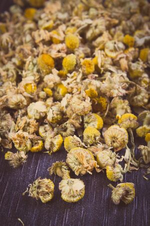 Vintage photo, Heap of dried chamomile lying on wooden surface, concept of healthy nutrition, herbalism and alternative medicineの写真素材