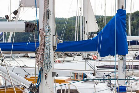 Yachting, parts of sailboat in port of sailing, coiled rope, sail, details of yacht