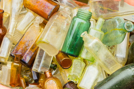 Heap of antique old dirty bottles for sale on stall at the bazaar as background