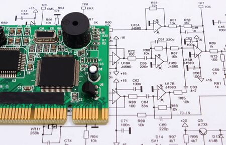 Printed circuit board with electrical components lying on construction drawing of electronics,...