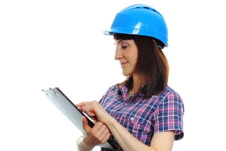 Smiling female construction worker holding documents and wearing protective blue helmet, safety at...