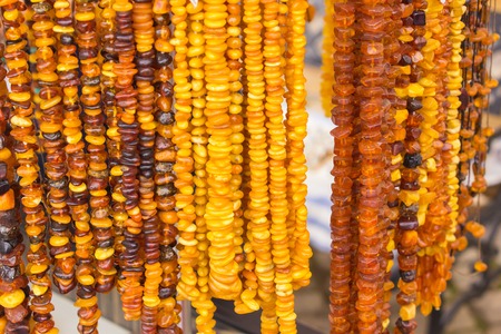 Orange shiny amber necklace, shopping jewelry and womanly accessories on stall at the bazaarの写真素材