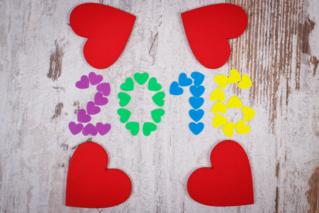 Happy new year 2016 made of colorful paper hearts and red wooden hearts on old wooden rustic backgroundの写真素材