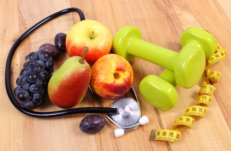 Medical stethoscope, fruits and dumbbells for using in fitness, concept of health care, healthy lifestyles and nutritionの写真素材