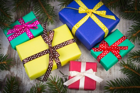 Wrapped colorful gifts for Christmas, birthday or other celebration and green spruce branches on old...