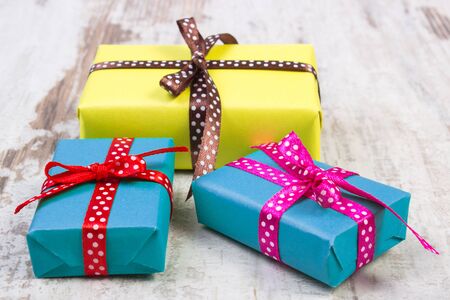 Wrapped colorful gifts for Christmas, birthday or other celebration on old wooden white plank