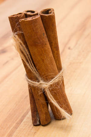 Cinnamon sticks lying on wooden table, seasoning for cooking and baking