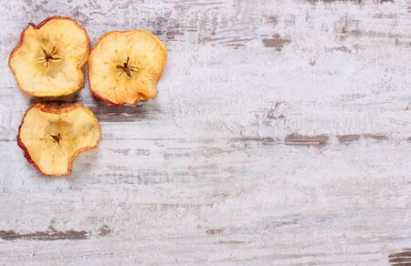 Slices of fresh dried apple lying on old rustic wooden background, copy space for textの写真素材