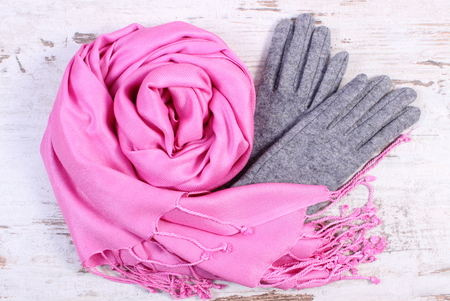 Woolen gloves and shawl for woman on old rustic wooden background, womanly accessories, warm clothing for autumn or winterの写真素材