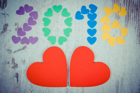 Vintage photo, Happy new year 2016 made of colorful paper hearts and red wooden hearts on old wooden...