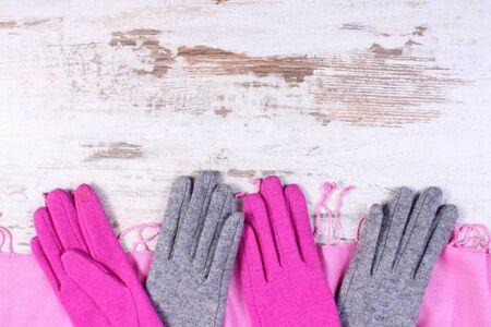 Frame of woolen gloves and shawl with copy space for text, womanly accessories, warm clothing for autumn or winter, old rustic wooden backgroundの写真素材