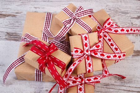Wrapped gifts in old vintage recycled paper tied colorful ribbon for Valentines or other celebration...
