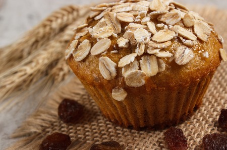 Fresh muffin with oatmeal baked with wholemeal flour and ears of rye grain, concept of delicious, healthy dessert or snackの写真素材