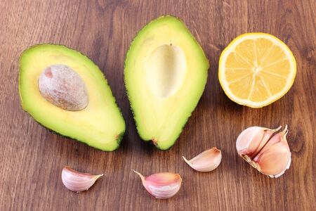 Portion of avocado, clove garlic and lemon, concept of healthy food, nutrition and omega fatty acids, ingredient of avocado paste or guacamoleの写真素材