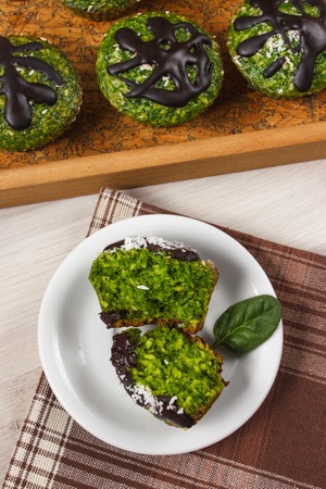Homemade muffins baked with wholemeal flour with spinach, desiccated coconut and chocolate glaze, delicious, healthy dessert or snackの写真素材