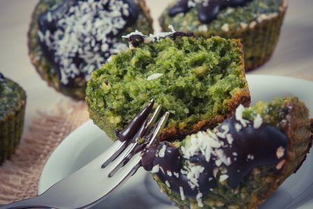 Vintage photo, Homemade muffins baked with wholemeal flour with spinach, desiccated coconut and chocolate glaze, delicious, healthy dessert or snackの写真素材
