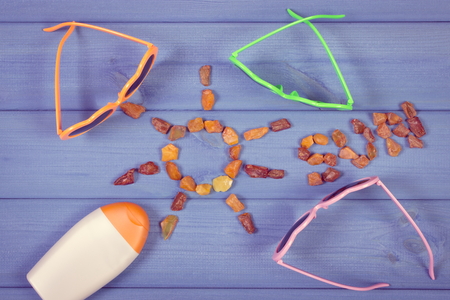 Vintage photo, Shape of sun with word sun made of amber stones and accessories for vacation and summer, sunglasses, sun lotionの写真素材