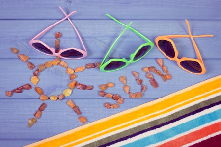 Vintage photo, Shape of sun with word sun made of amber stones and accessories for vacation and summer, sunglasses, towelの写真素材