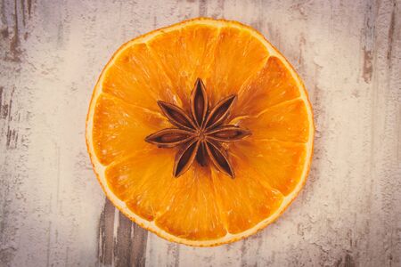 Vintage photo, Slice of fresh dried orange and star anise lying on old rustic wooden backgroundの写真素材