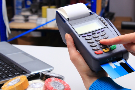 Hand of woman using payment terminal in an electrical shop, paying with credit card, credit card...