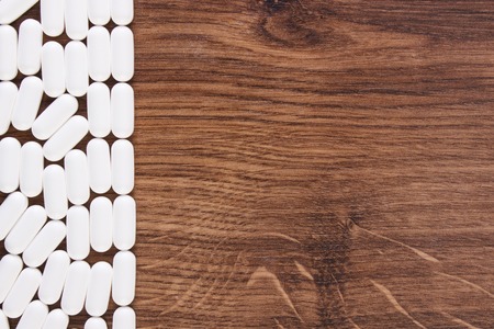 Heap of white medical pills, capsules or supplements for therapy, concept of treatment and health care, copy space for text or inscriptionの写真素材