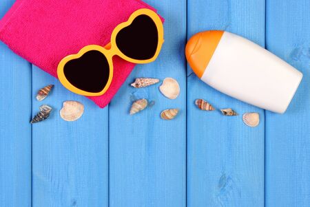 Accessories for summer and vacation and seashells, sunglasses, towel and sun lotion, copy space for...