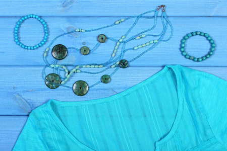 Clothing for woman and accessories for vacation and summer on blue boards, shirt, jewelry